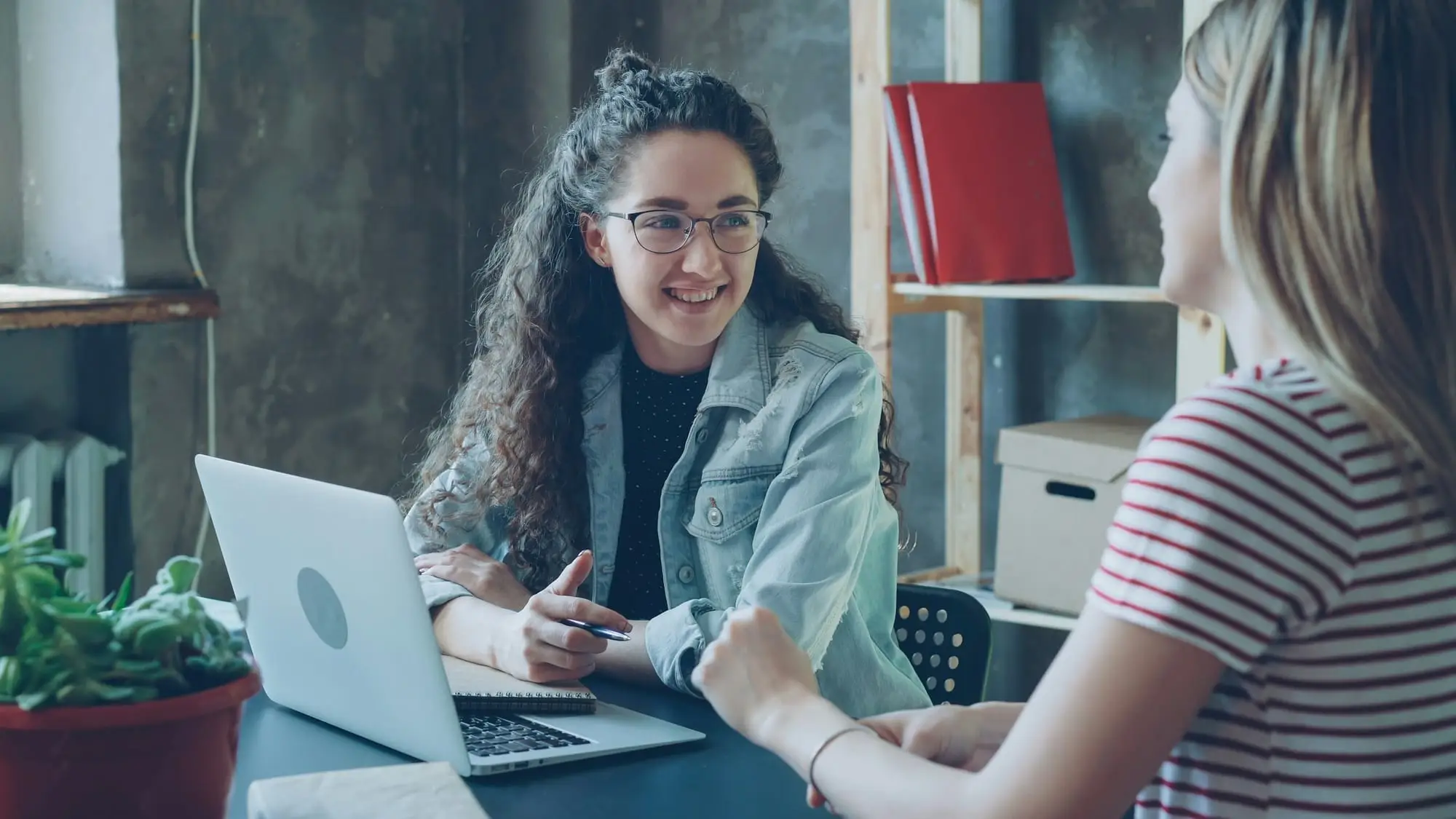 Two people discussing a system architecture in front of a laptop screen